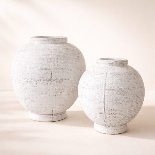 Two textured white ceramic jars on a light background