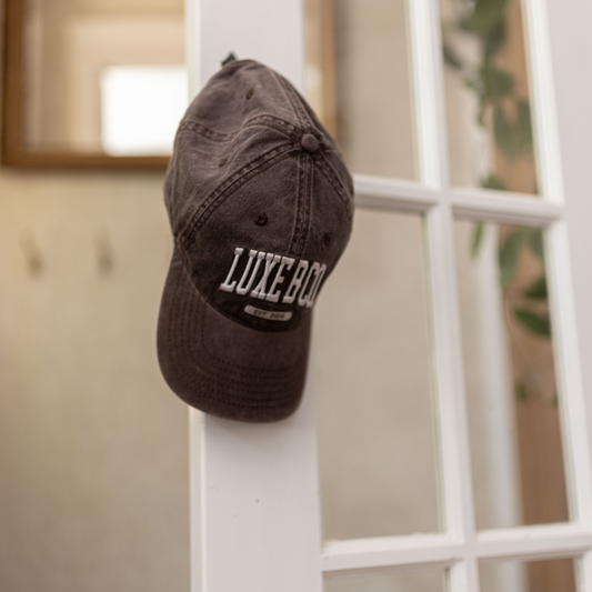 Luxe B Co. brown baseball cap with adjustable strap, featuring a classic curved brim and minimalist design.