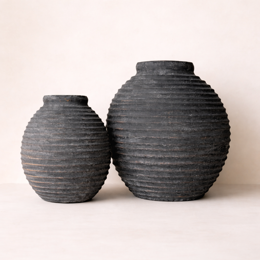 Two black textured vases on a white background