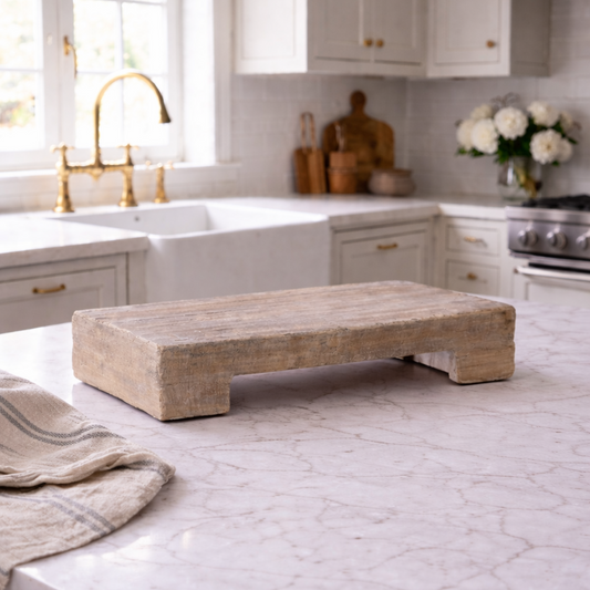 Modern kitchen with a stone cutting board on a marble countertop.