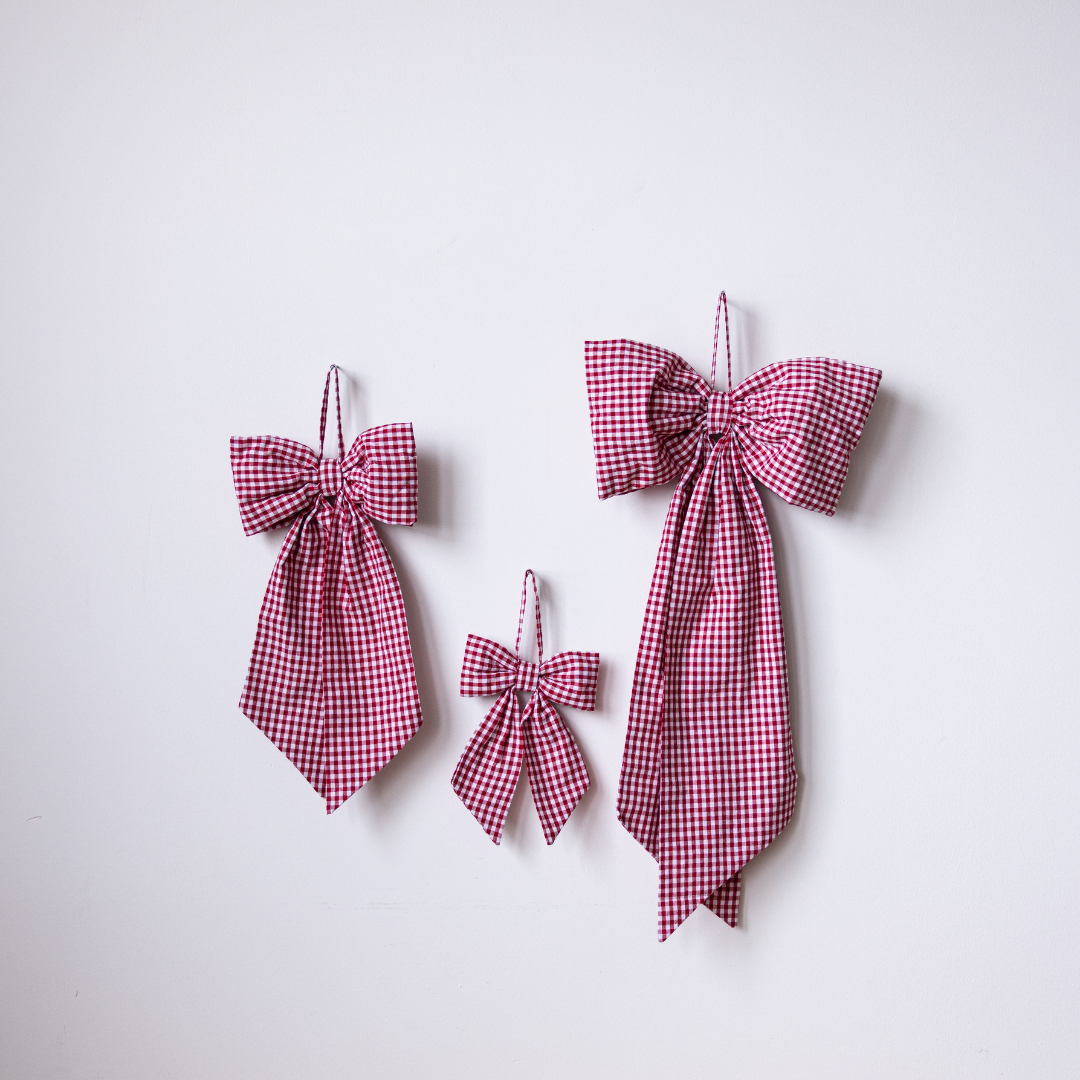 Red gingham fabric bows by Luxe B Co, featuring classic pattern and soft material, perfect for gift wrapping or hair accessories.