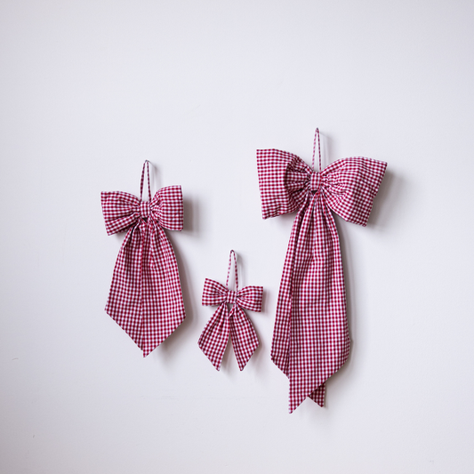 Red gingham fabric bows by Luxe B Co, featuring classic pattern and soft material, perfect for gift wrapping or hair accessories.