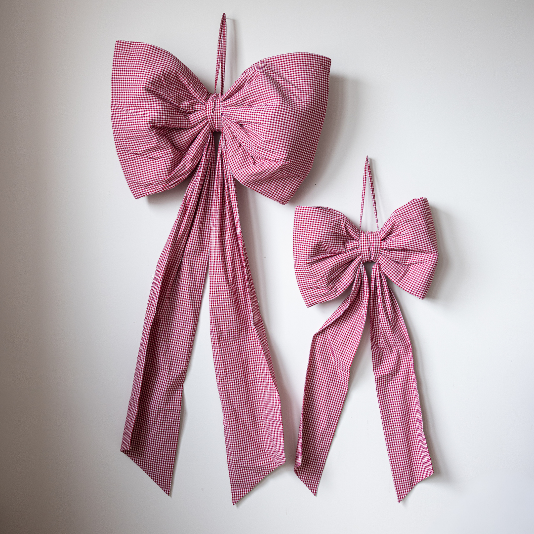 Luxe B Co oversized red gingham bow, large fabric accessory with a classic checkered pattern and tied bow design.