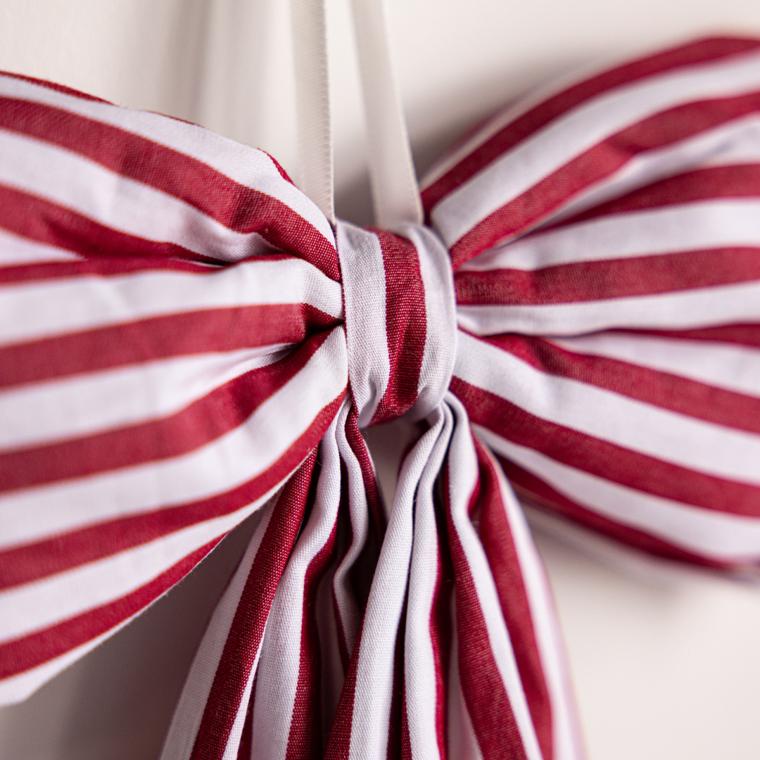 Red fabric bows with candy cane pattern from Luxe B Co, perfect for gift wrapping and holiday decorations.