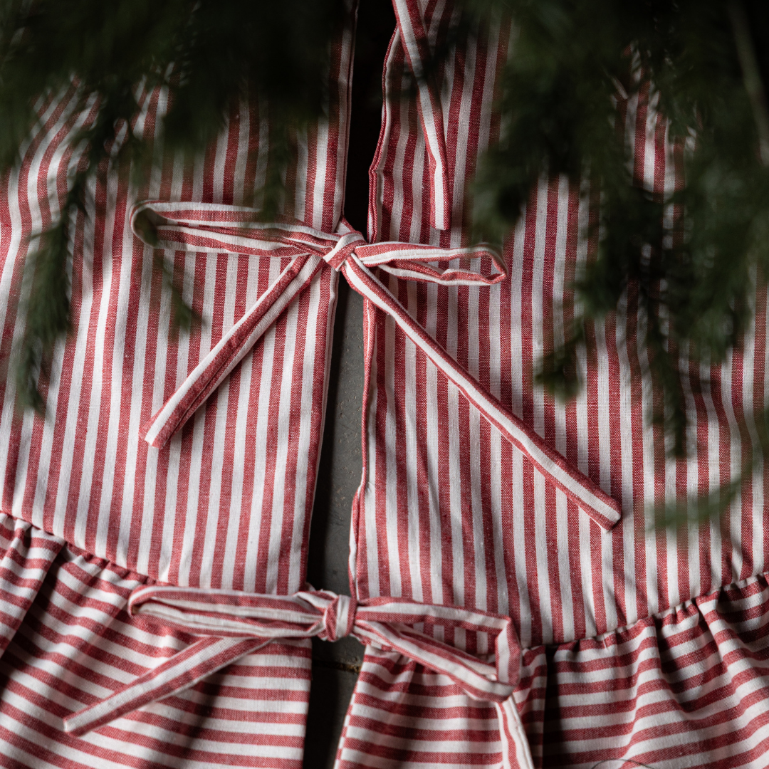 Red Stripe Ruffle Tree Skirt by Luxe B Co. featuring ruffled edges and festive red and white stripe pattern for holiday decor.