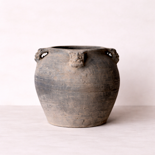 Vintage-style terracotta pot with decorative handles on a white background
