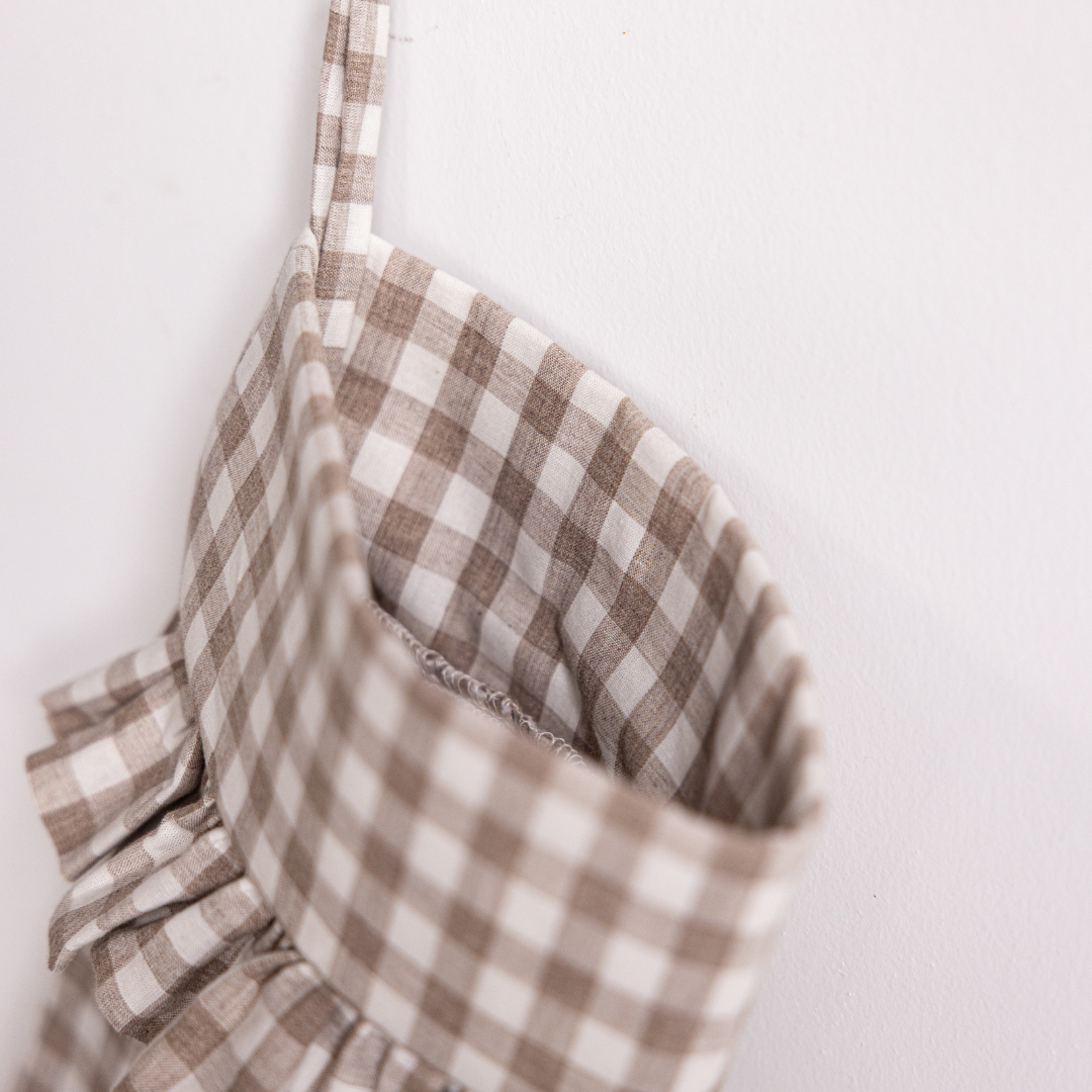 Beige gingham holiday stocking by Luxe B Co with festive pattern and plush cuff for Christmas decor.