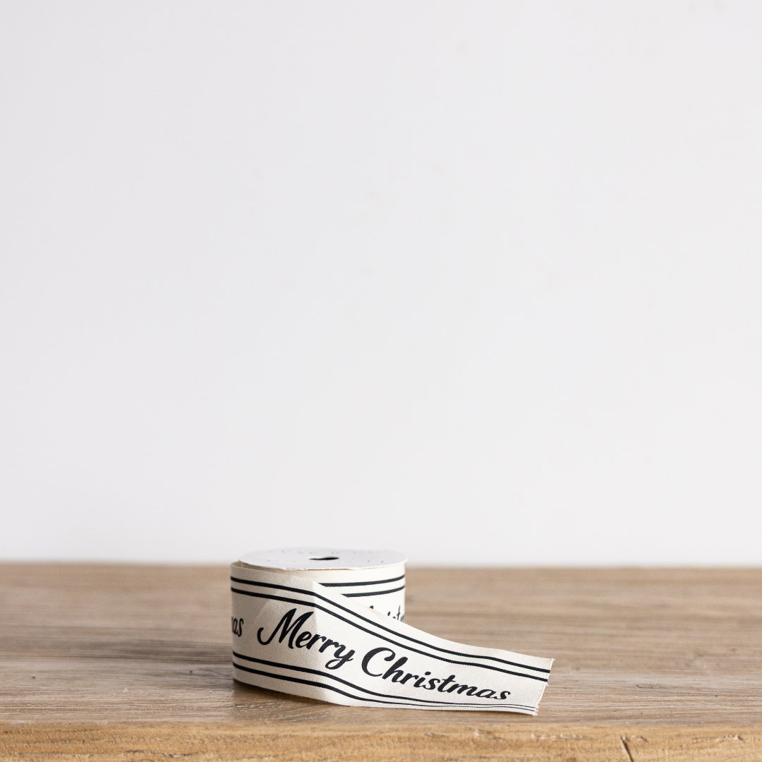 Black cursive Merry Christmas ribbon by Luxe B Co Wholesale, featuring elegant holiday festive script on satin fabric.