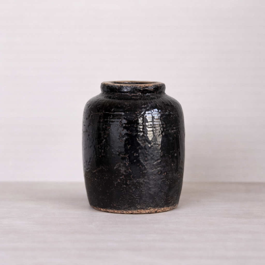 Black ceramic jar on a light gray background