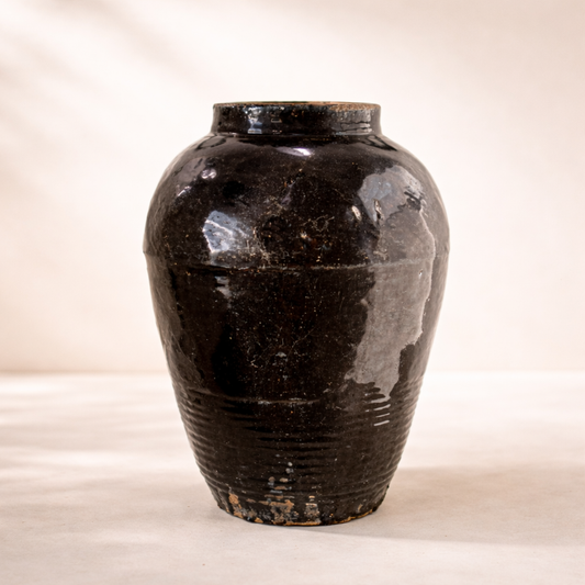 Black ceramic vase on a beige background