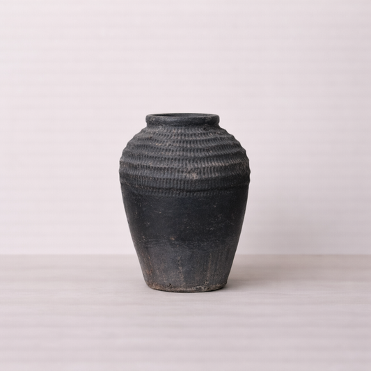 Black textured vase on a light gray background