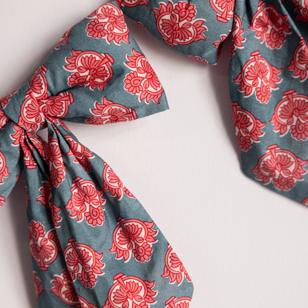 Blue and coral floral block print fabric bows arranged in a holiday garland, decorative mini bows by Luxe B Co.