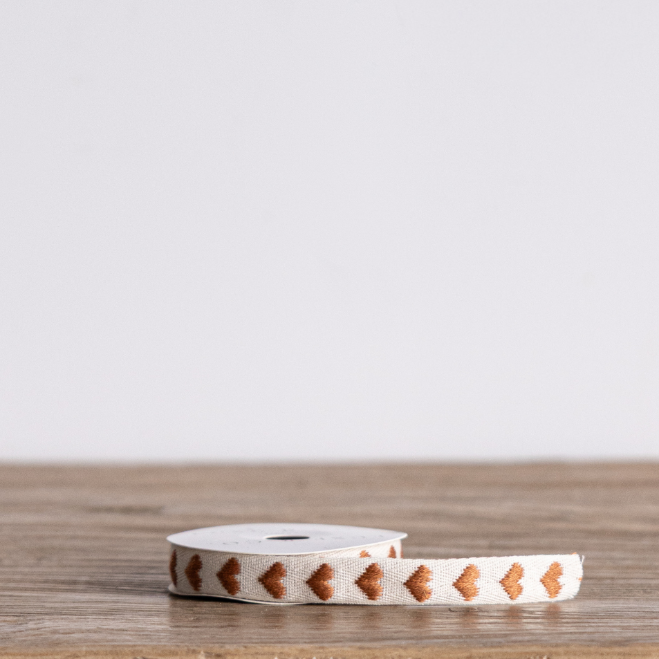 Brown hearts woven ribbon by Luxe B Co, featuring a textured fabric with a charming heart pattern, ideal for gift wrapping and crafts.