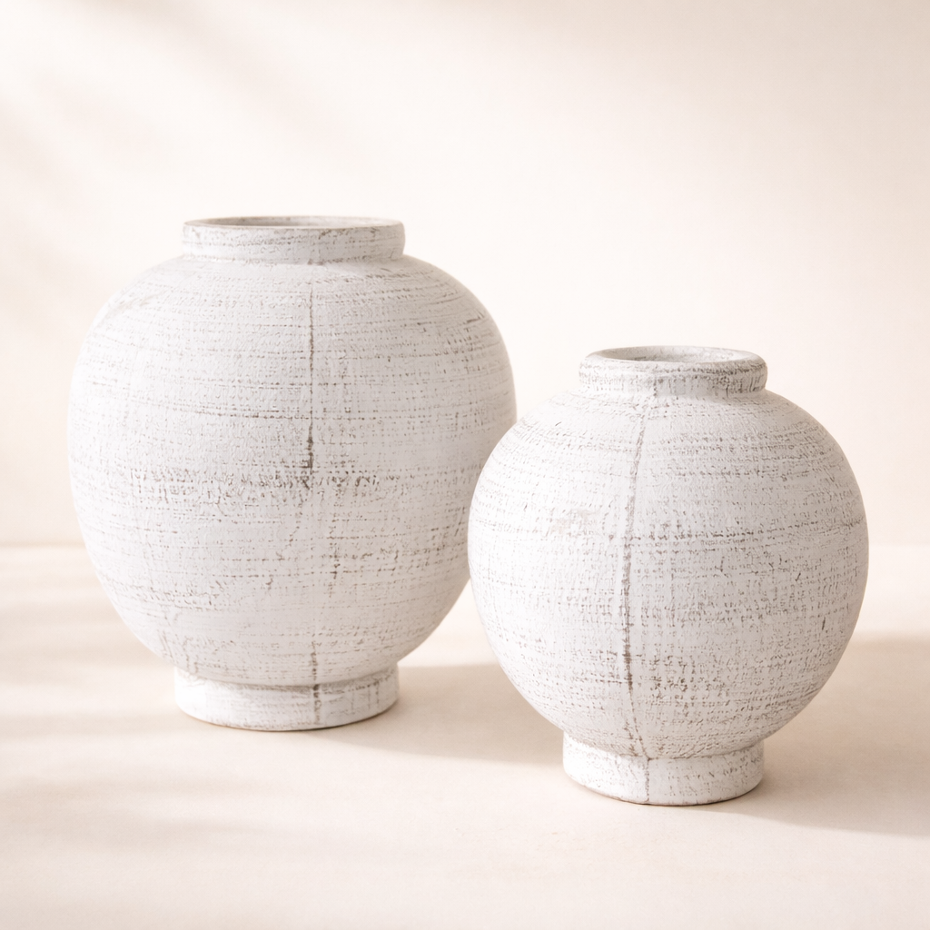 Two textured white ceramic jars on a light background