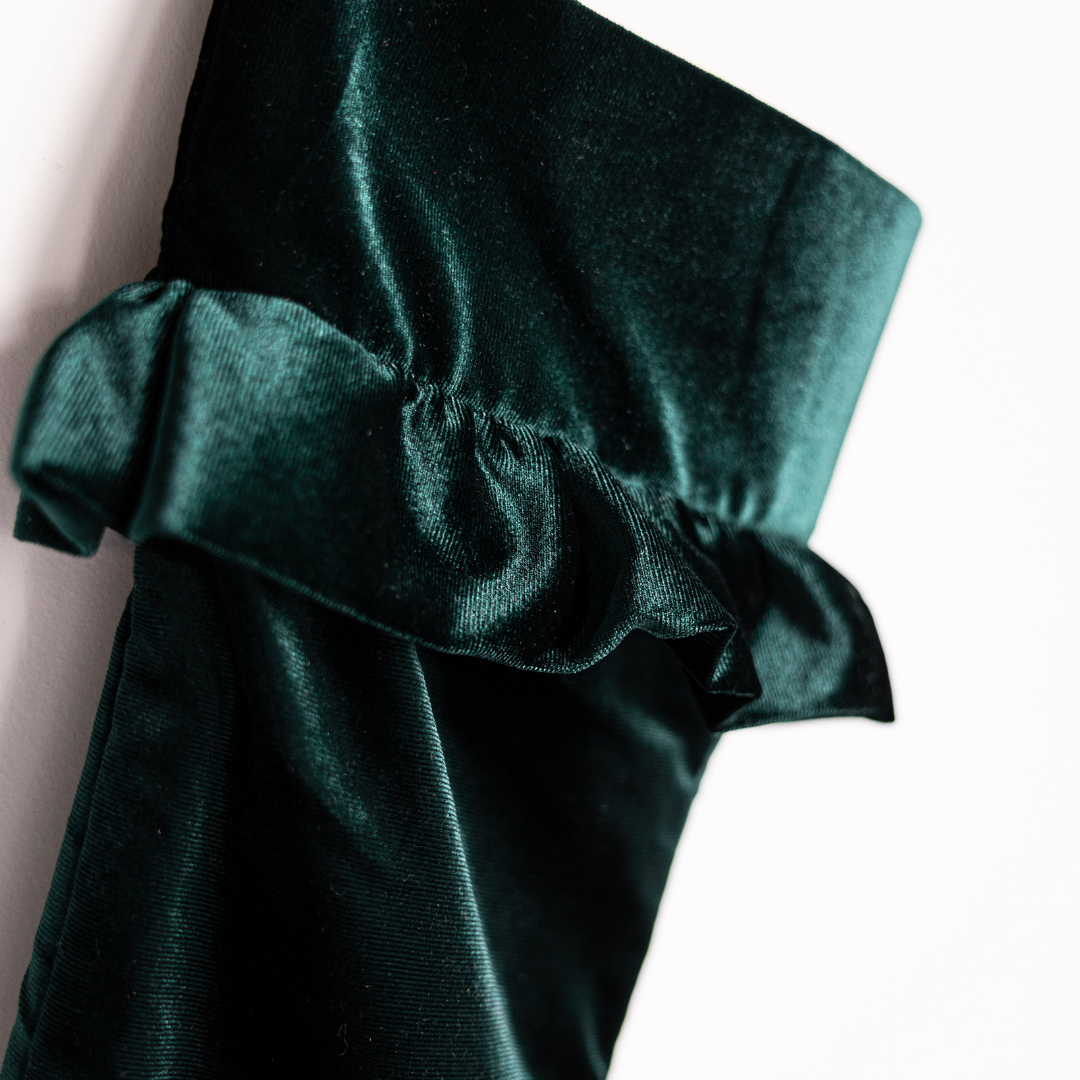 Emerald velvet holiday stocking by Luxe B Co with plush fabric and festive design, perfect for Christmas decor and gift filling.
