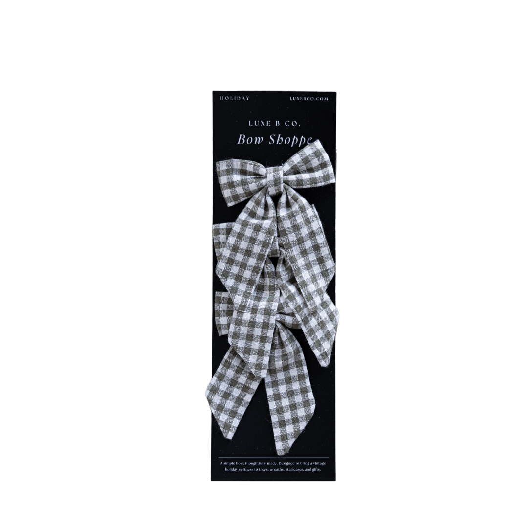 Set of small green gingham fabric bows with attached clips, perfect for hair accessories or decorative accents.