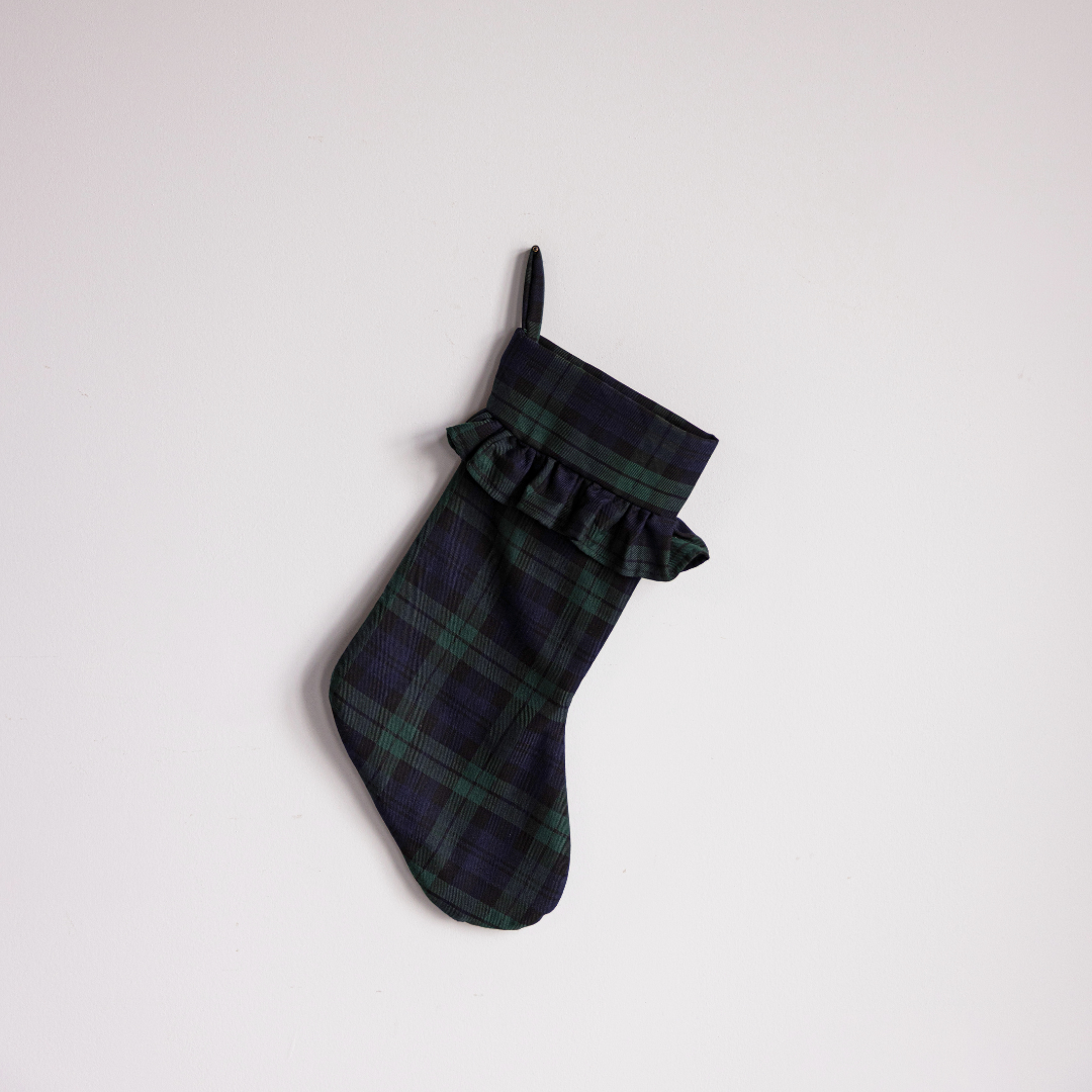 Green plaid holiday stocking by Luxe B Co with festive pattern, perfect for Christmas decoration and gift hanging.