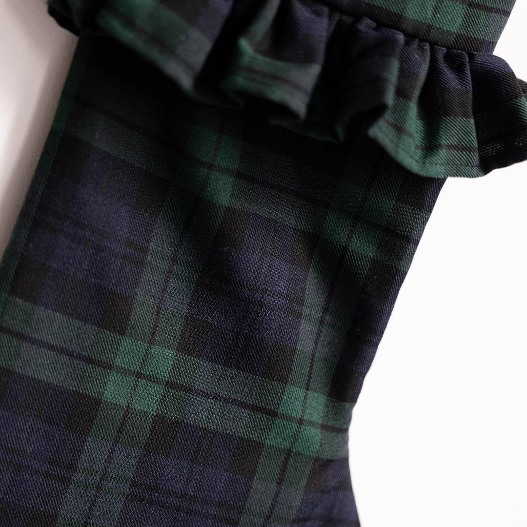 Green plaid holiday stocking by Luxe B Co hanging with festive decor, featuring a cozy, traditional design.