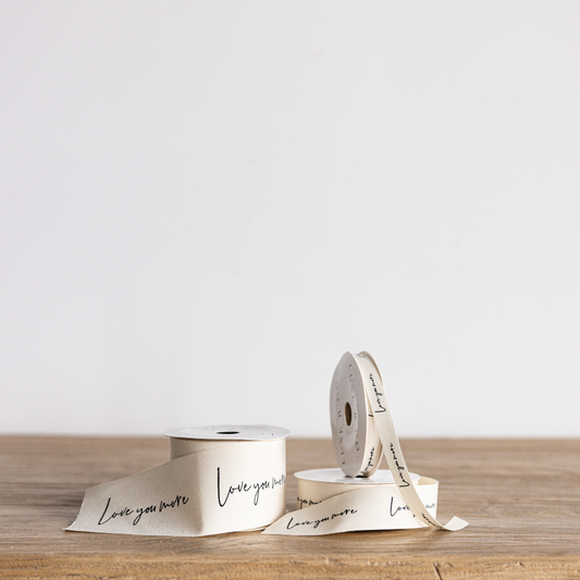 Cursive writing ribbon with "Love You More" text in elegant script, made by Luxe B Co Wholesale, showing detailed design and texture.