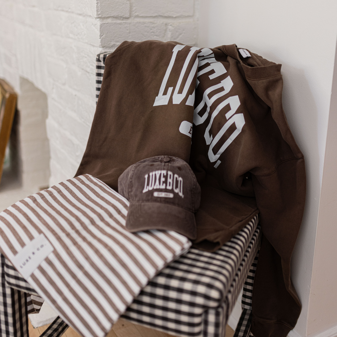 Brown Luxe B Co. pullover sweater, cozy knit fabric, displayed on a hanger with a relaxed fit and ribbed cuffs.