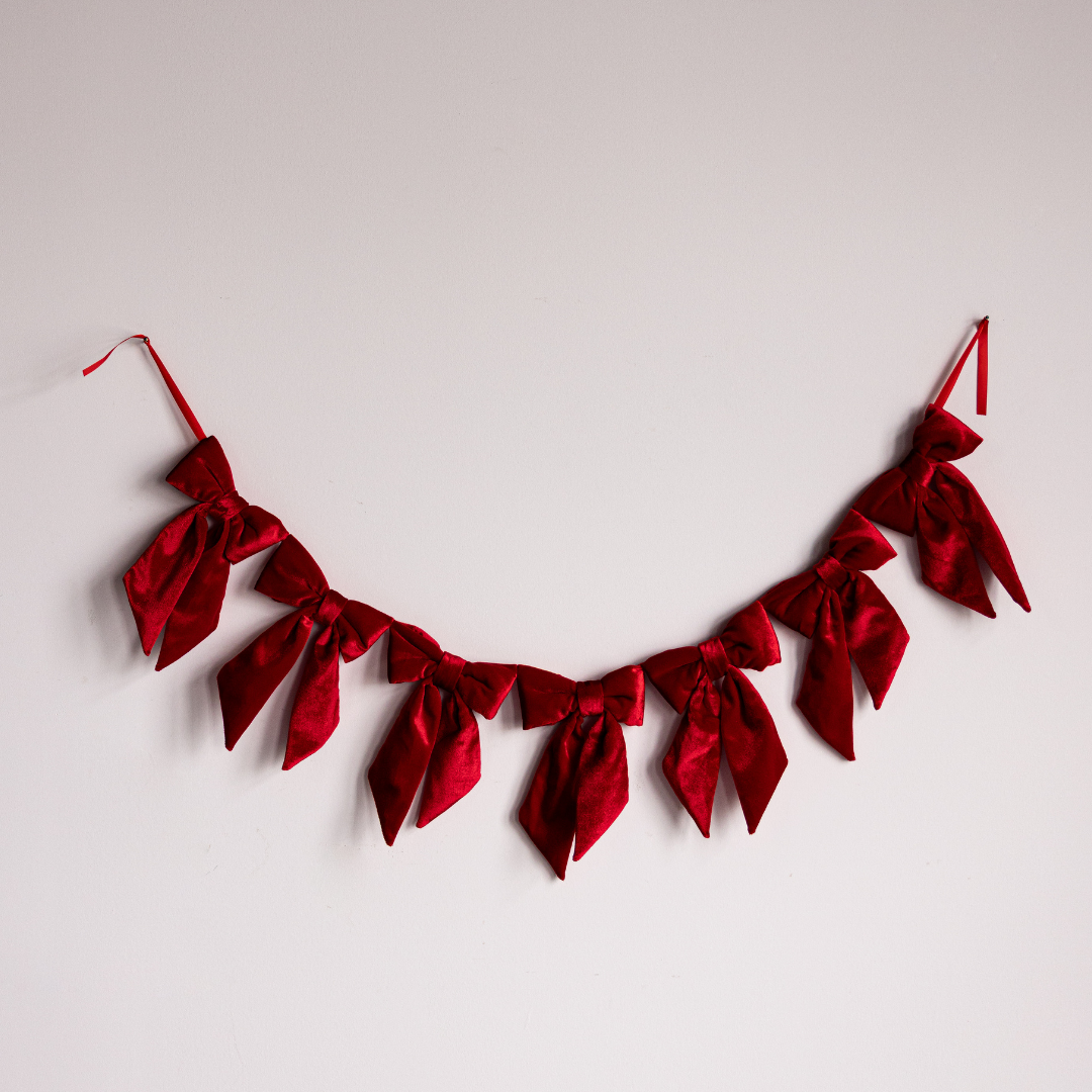 Red velvet fabric bows on a garland by Luxe B Co, perfect for decorating with elegant, soft fabric bows.