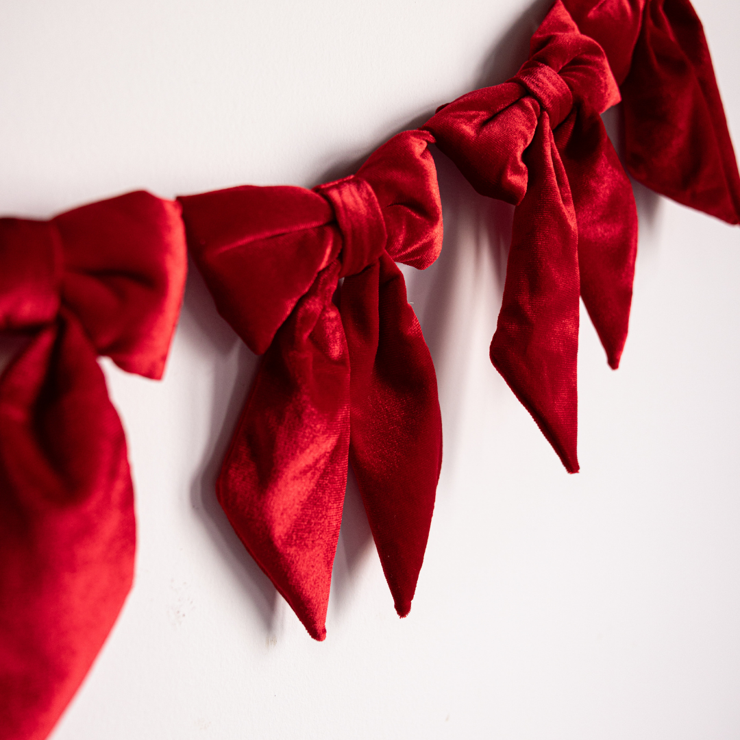 Red velvet fabric bow garland with large decorative bows, ideal for festive or elegant decor by Luxe B Co.