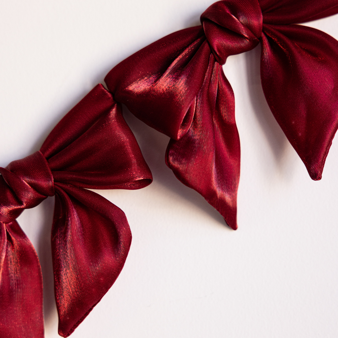 Red gauze bow garland with multiple soft fabric bows, perfect for decorative events, by Luxe B Co.