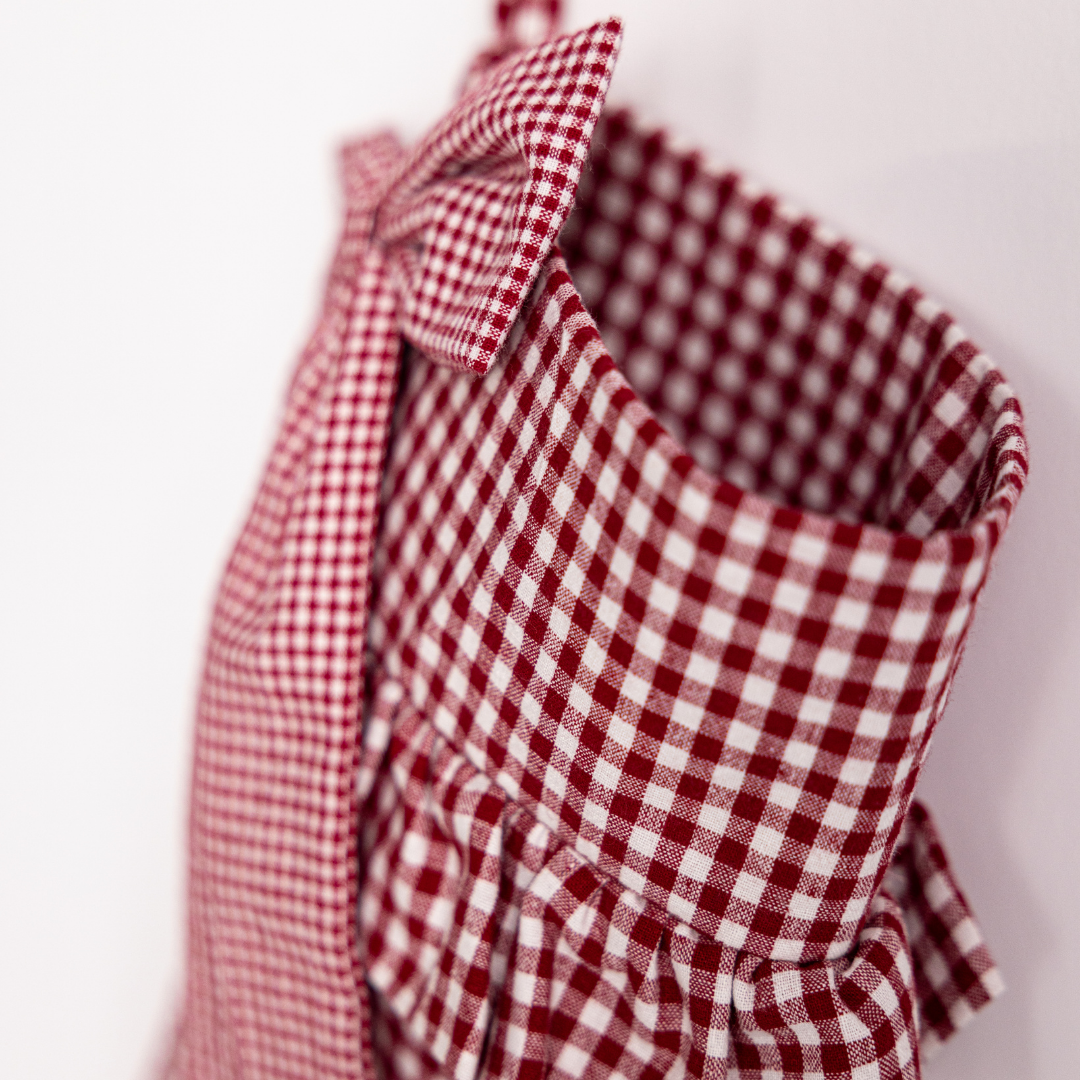 Red gingham holiday stocking with a large bow by Luxe B Co, showcasing festive Christmas stocking with decorative bow detail.