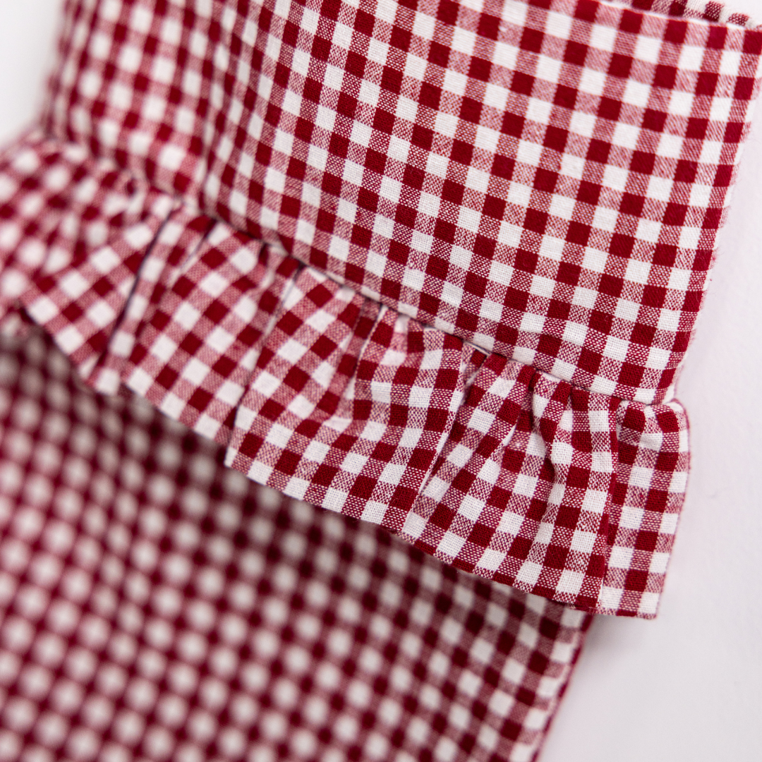 Red gingham holiday stocking by Luxe B Co, showcasing a festive red and white checkered design with plush trim.