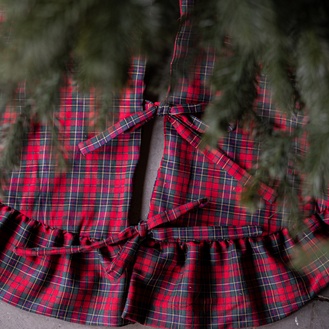 Red plaid ruffle tree skirt from Luxe B Co., featuring a festive design with ruffled edges for holiday decorating.