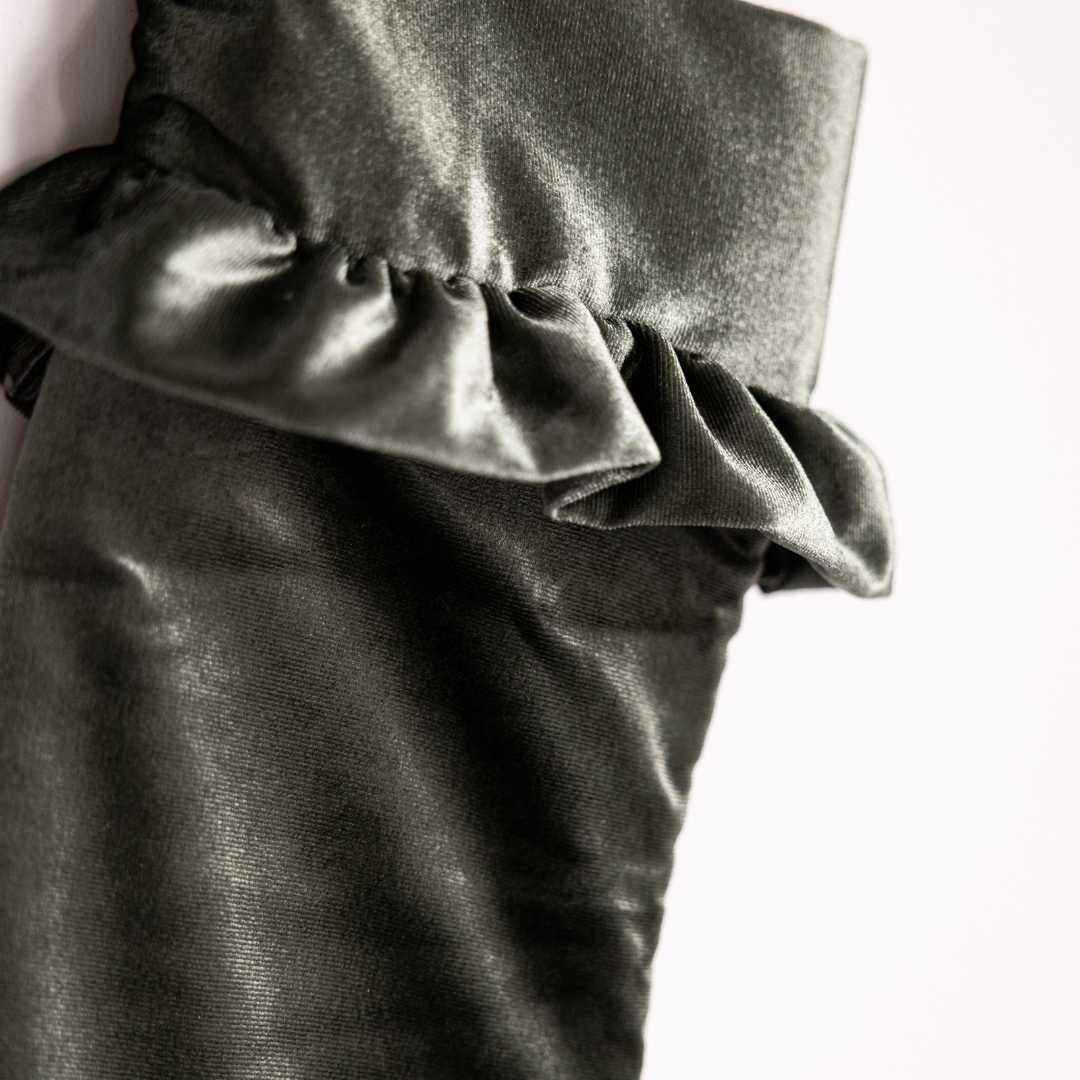 Sage velvet holiday stocking by Luxe B Co hanging with a plush cuff and decorative details for festive decor.