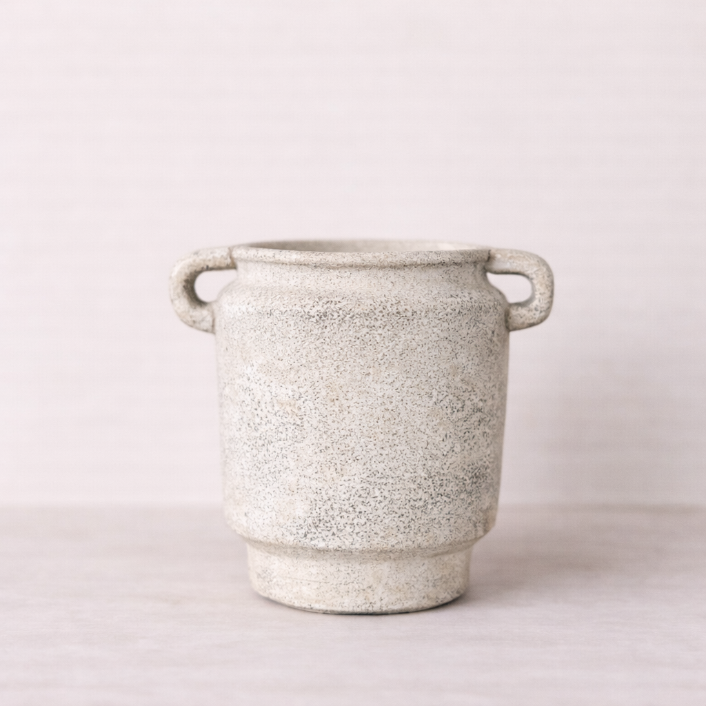 Speckled gray ceramic planter with handles on a light background