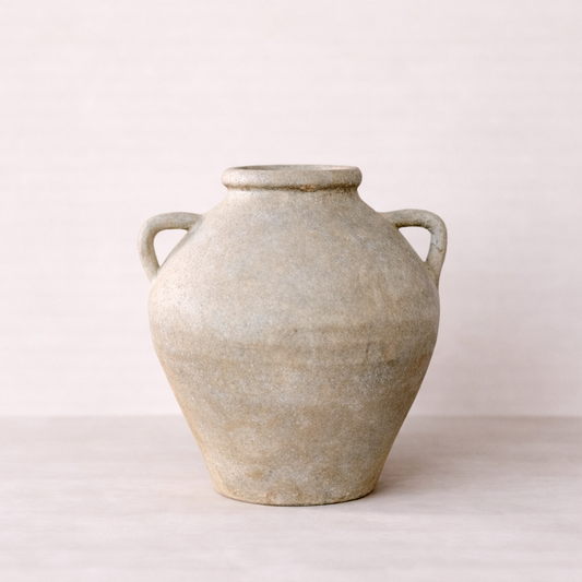 Vintage-style ceramic jar with handles on a white background