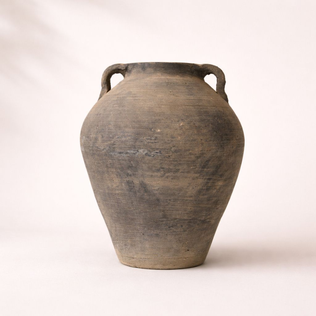 Vintage terracotta jar with handles on a white background