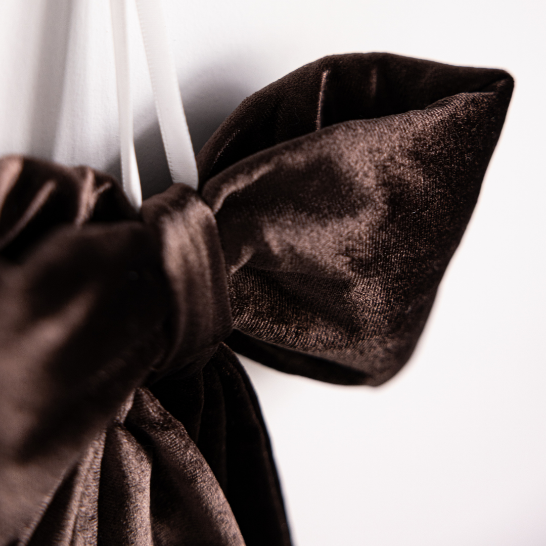 Close-up of Luxe B Co brown velvet fabric bow, showcasing soft texture and elegant design on a neutral background.